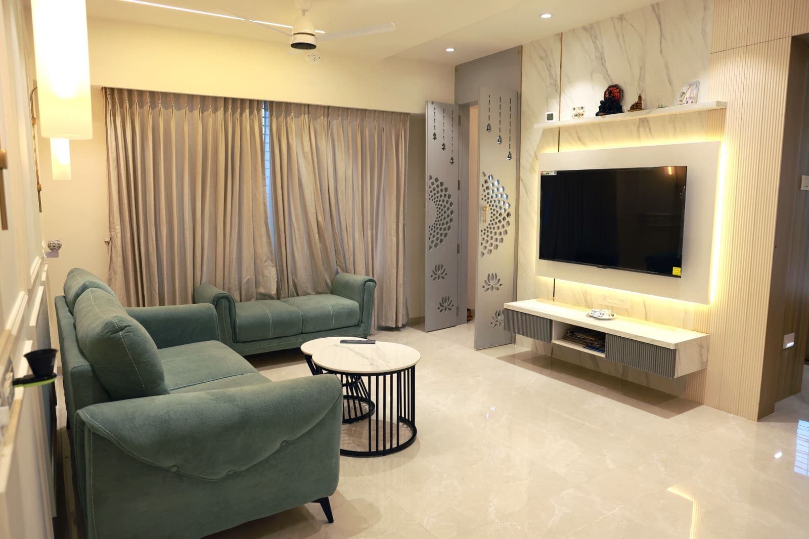 Living room seating facing a backlit marble media wall