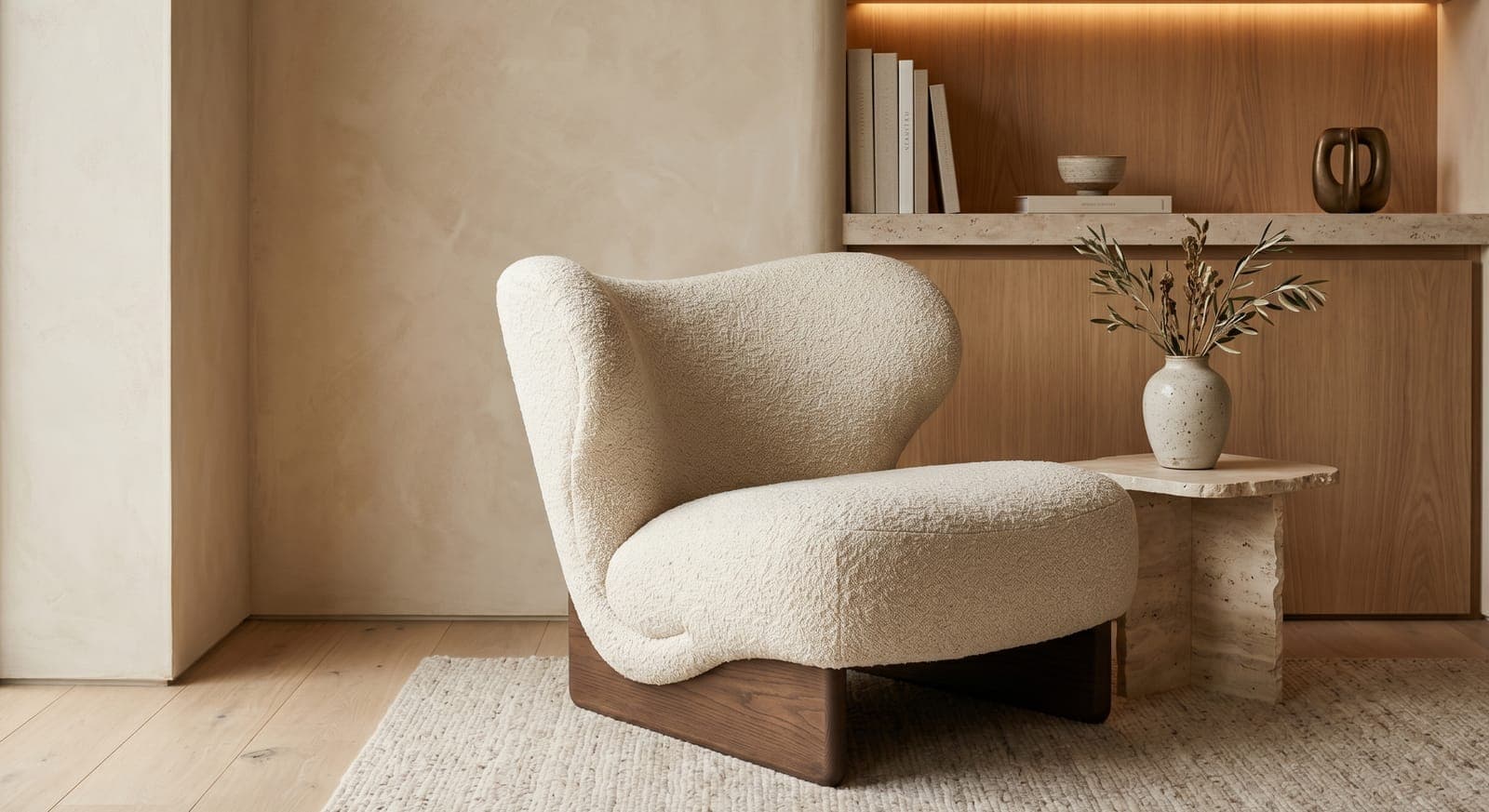 Cream boucle lounge chair on an oak floor beside a limewash wall